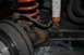 1974 Ford Bronco - This image shows a close-up of a vehicle's suspension system, focusing on rusty components and a shock absorber.