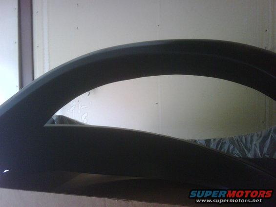 Black fender flare, curved shape, close-up view