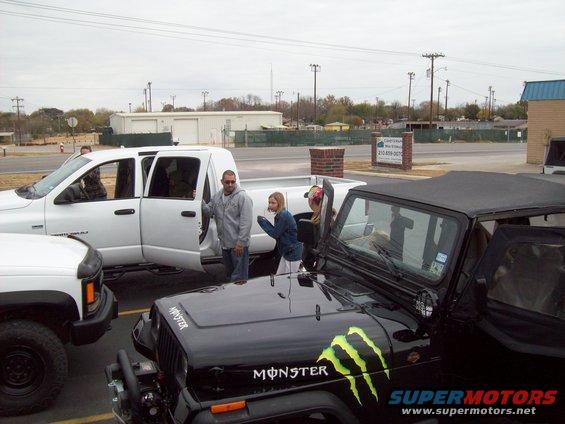 Black Jeep Wrangler with Monster Energy decals, front 3/4 view