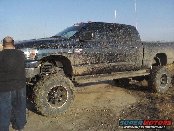 Muddy black Dodge Ram 3500 pickup truck with lifted suspension and large tires