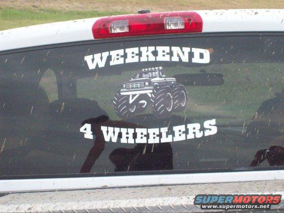 White truck rear window with "WEEKEND 4 WHEELERS" sticker and monster truck graphic