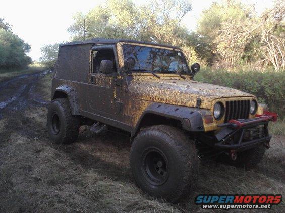 Mud-covered yellow Jeep Wrangler with Rubicon badging