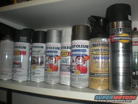 Spray paint cans on a shelf, including Rust-Oleum primer, metallic, hammered, and professional high performance enamel