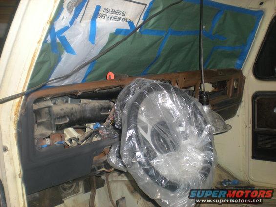 1978 Ford Bronco dashboard with steering wheel covered in plastic, undergoing repairs
