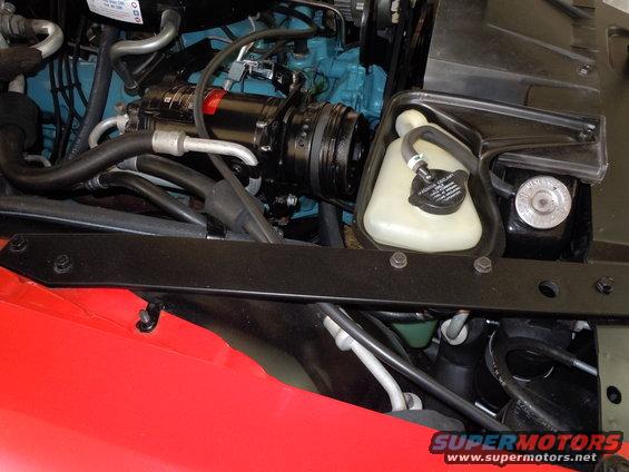 Red fender and black engine components including AC compressor and coolant reservoir