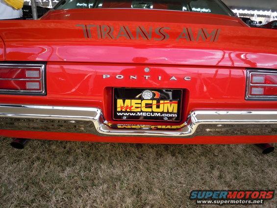 Red Pontiac Trans Am rear with Mecum license plate and chrome bumper