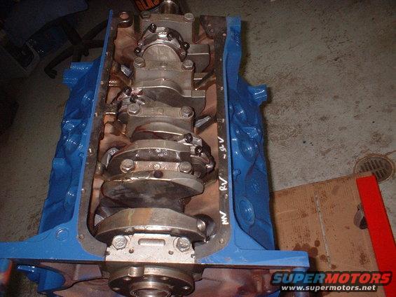 Blue engine block with crankshaft and connecting rods visible. Some writing on the side