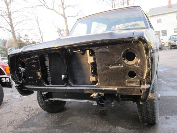 Black truck front end with grille removed, showing radiator support and headlight openings