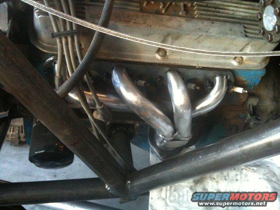 Engine block with chrome exhaust headers and spark plug wires, viewed from below