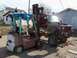 1987 Ford Ranger - A red pickup truck chassis sits next to a Datsun forklift in a yard.