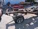 1987 Ford Ranger - Disassembled truck frame and red bed sit in a yard, with a single tire and wheel in the foreground.