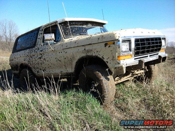Muddy 1978 Ford Bronco on grassy terrain