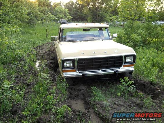 Tan Ford F-Series truck stuck in mud, front view