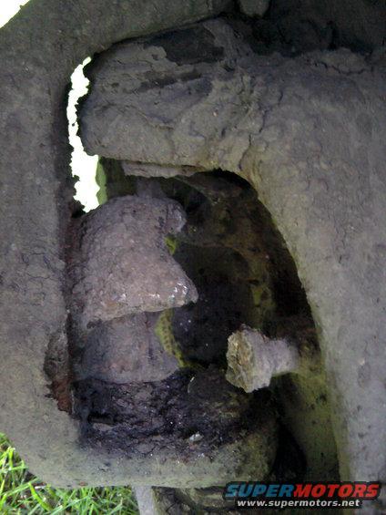 close-up of a heavily rusted and dirty suspension component, possibly a ball joint or tie rod end