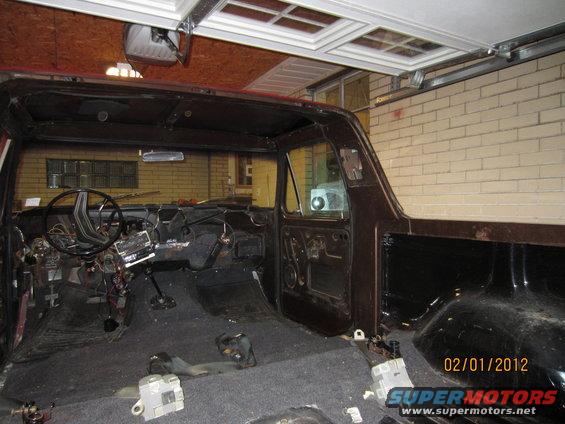 1979 Ford Bronco interior stripped down, showing dashboard, steering wheel, and empty cabin