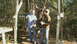 1993 Ford Bronco - Two men pose with a deer carcass hanging from a wooden frame in a wooded area.