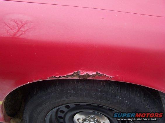 Red car fender rust around wheel well