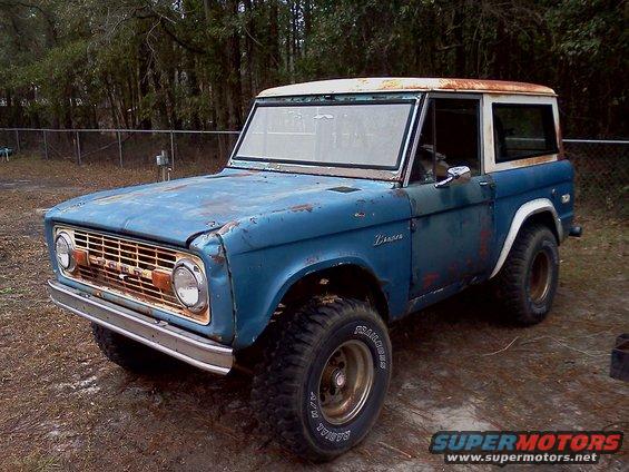Blue 1974 Ford Bronco with a white hardtop, showing rust and wear