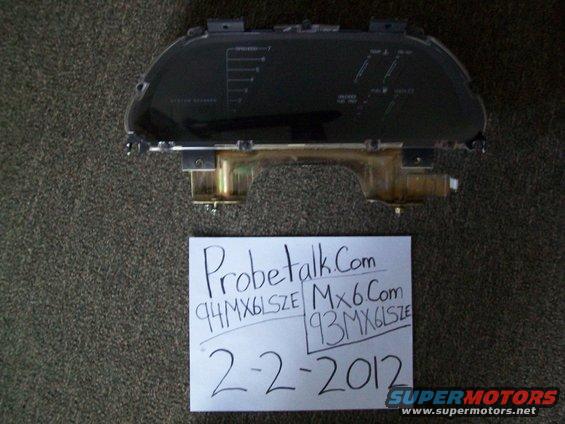 Car dashboard gauge cluster with text 'Probetalk.Com 94MX6LSZE Mx6Com 93MX6LSZE 2-2-2012' and Supermotors logo