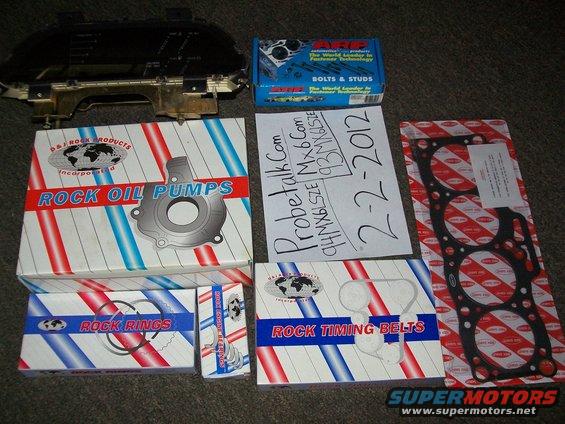 Car parts including oil pump, timing belts, and gasket, with a dashboard