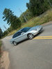 Silver 1998 Ford Taurus sedan, angled from the front-right, driving on a paved road with yellow lines