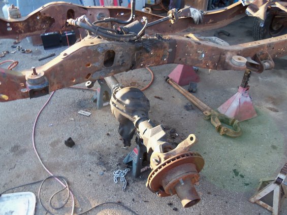 rusted truck frame on jack stands with rear axle removed