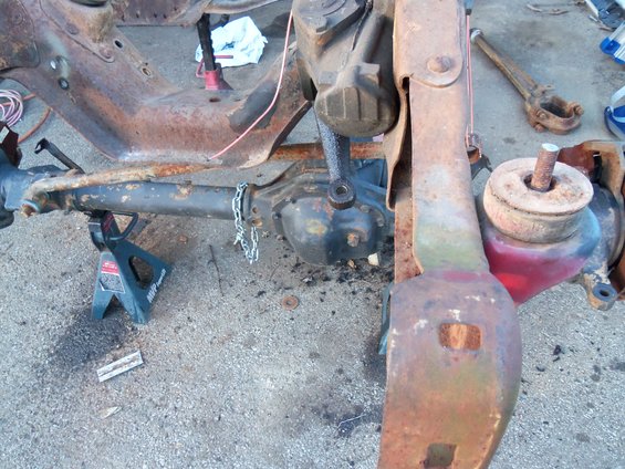 Rusted truck frame and suspension parts on jack stands