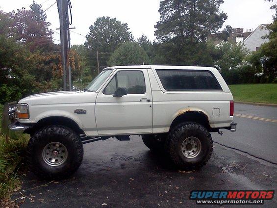 White 1996 Ford Bronco lifted with large tires, side view