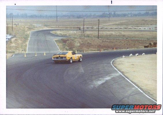 yellow race car with number 15 on door driving on a track