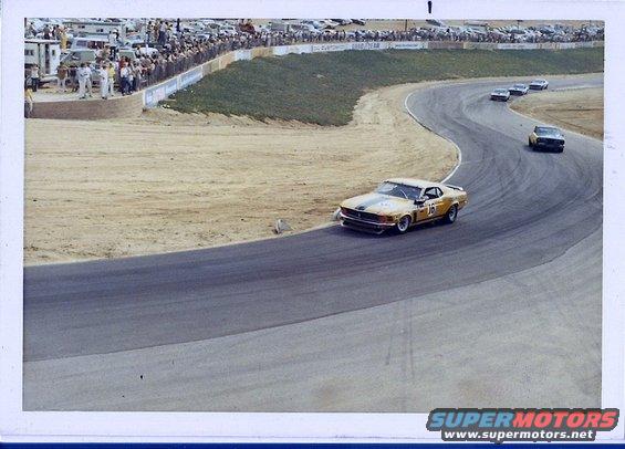 Yellow race car with green stripes and number 16 on a race track