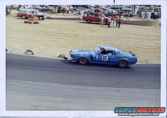 Blue race car with number 82 on the side, gold wheels, and racing decals, viewed from the front-right