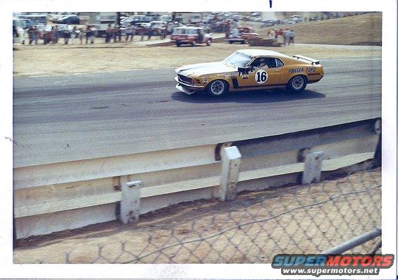 Yellow race car with number 16 and "FOLLMER FORD" text, 3/4 front view