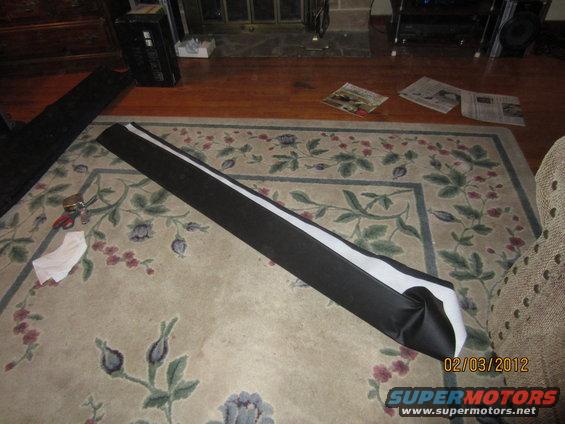 black and white car part on floral rug, with tools nearby