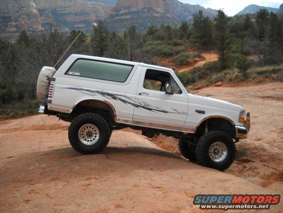 White 1996 Ford Bronco with off-road tires on rocky terrain