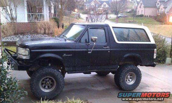 1996 Ford Bronco side view, black with white top, aftermarket bumper and lift kit