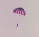 1976 Yamaha XS650 - A person parachutes under a striped canopy against a light sky.