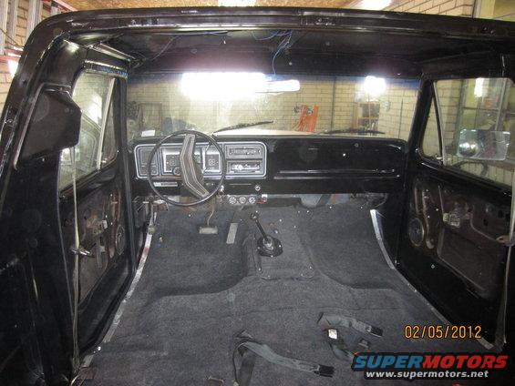 Interior of a 1979 Ford Bronco with carpet installed and door panels removed