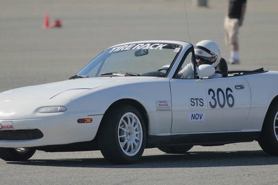 White 1991 Mazda Miata convertible with racing numbers and 'Tire Rack' sticker on windshield