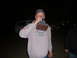 1988 Ford Bronco - A man holds a trophy to his mouth while standing in front of vehicles at night.