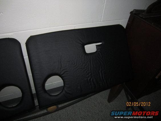 Two black car door panels with circular cutouts and a handle slot