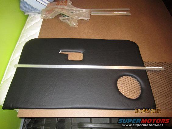 Black vinyl door panel with a circular speaker cutout and a horizontal metal trim piece