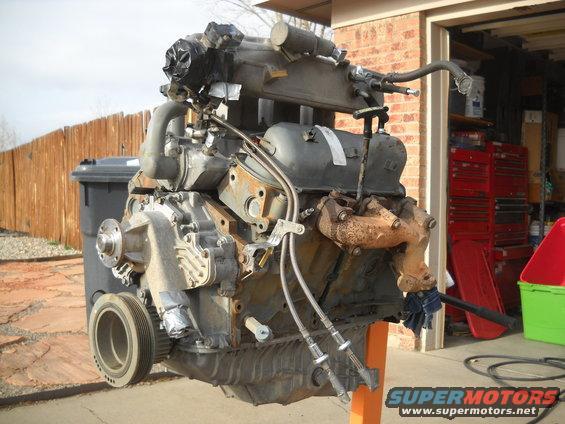 Engine on stand, front-right view. Supermotors.net logo visible