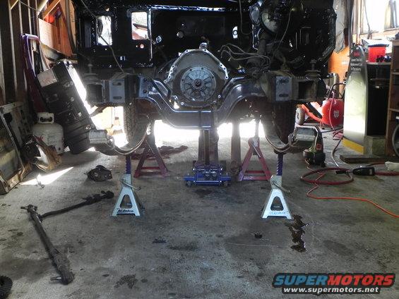 vehicle frame on jack stands, engine and transmission removed, garage setting