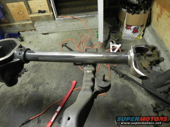 Front axle assembly with suspension components and a metal shaft