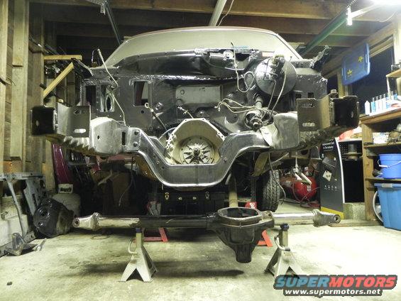 1993 Ford Bronco chassis on jack stands, front end removed, transmission visible