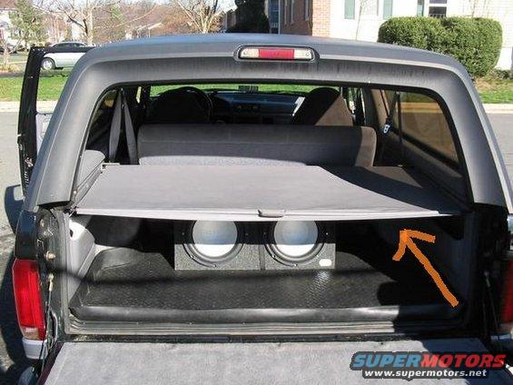 Rear interior of a 1996 Ford Bronco showing subwoofers and cargo cover