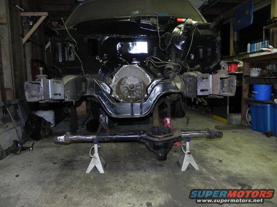 Vehicle frame on jack stands, engine exposed, front differential removed