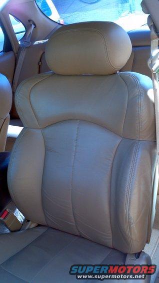 Tan leather car seats with visible stitching and seat belts