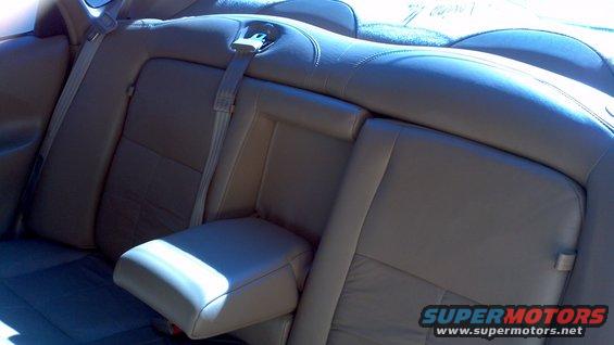 Back seat of a car with leather upholstery and seatbelts