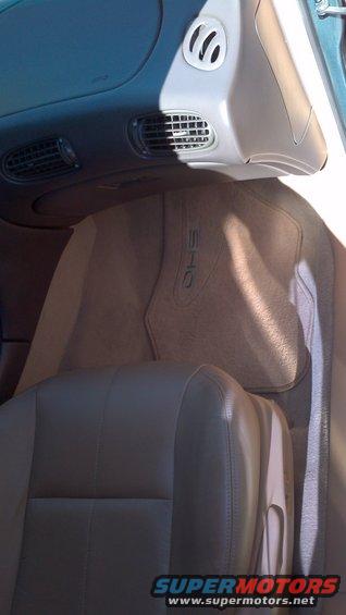 Car interior with tan leather seats and a floor mat with "SHO" embossed on it